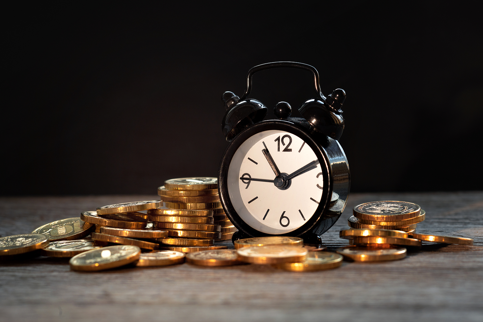 time and money, alarm clock next to a pile of coins, inflation concept, compound interest
