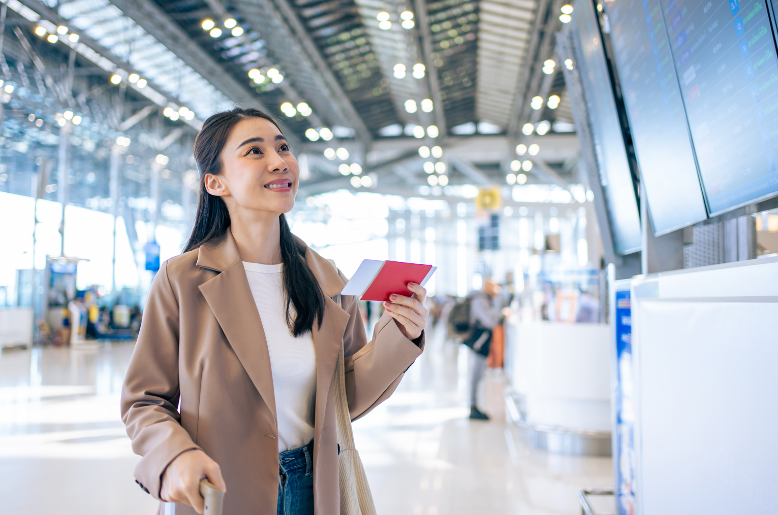 Asian young woman passenger after discovering are airline credit cards worth it checking departure boarding pass in airport.