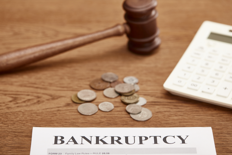 selective focus of what bankruptcy chapter to file form, gavel, calculator and coins on brown wooden table