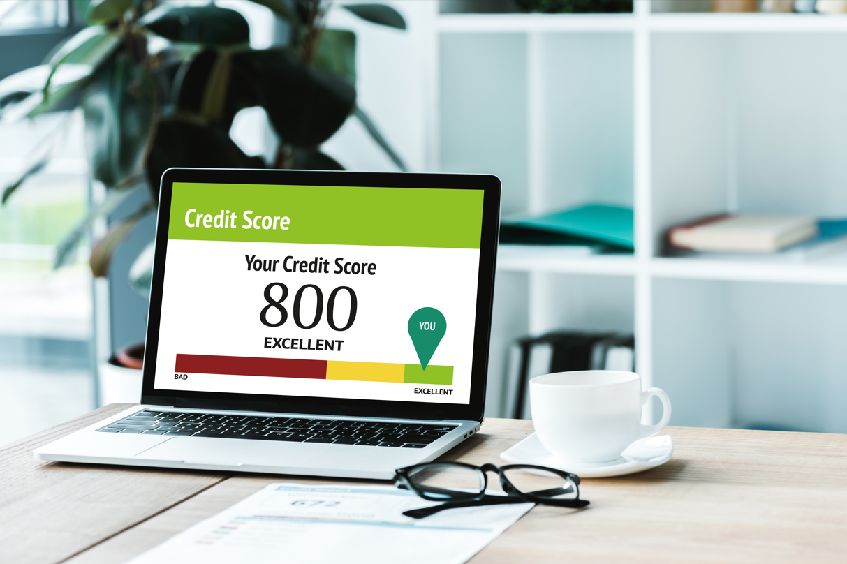 cup of coffee near laptop with different types of credit score models and lettering and numbers on screen