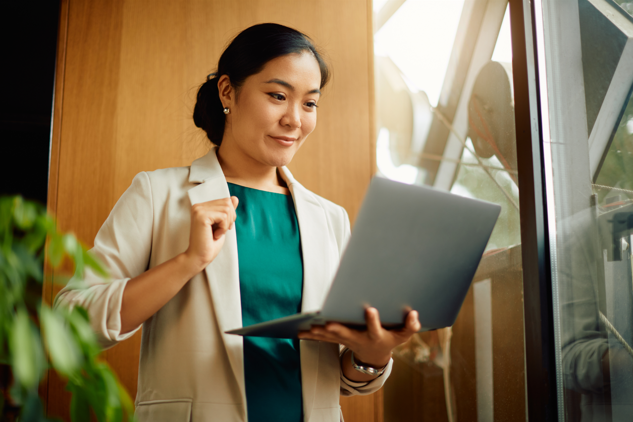 Young Asian businesswoman reading an e-mail on what is the equal ctedit opportunity act on laptop in the office.