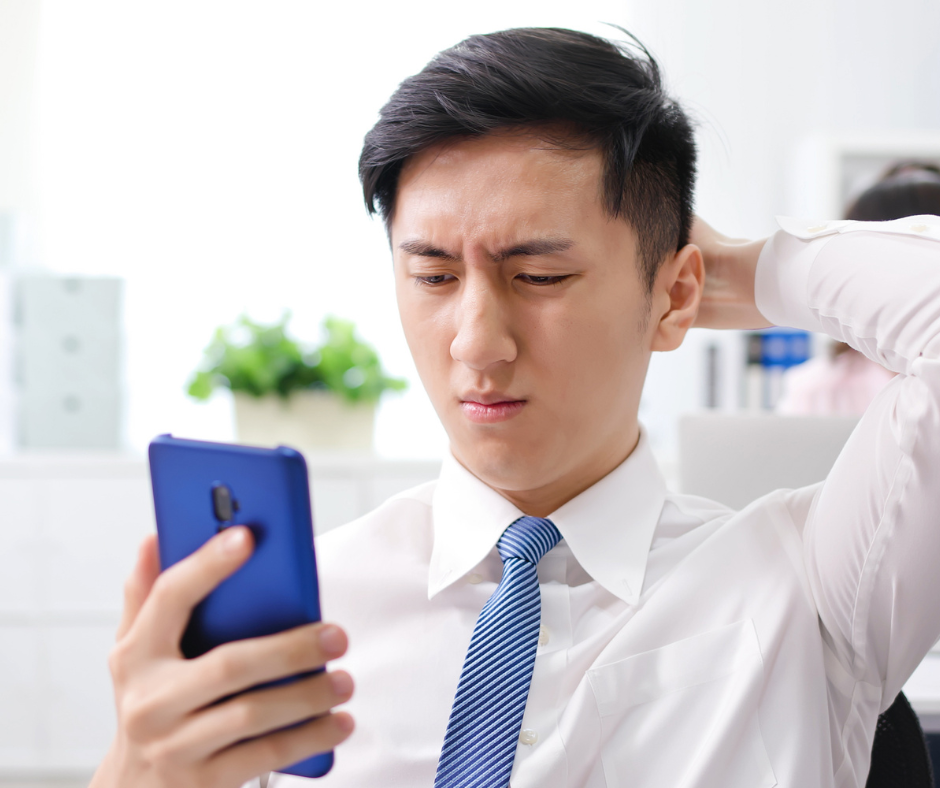 Man looking at phone learning how to improve credit approval odds after a rejection