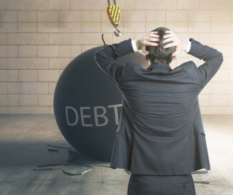 How small debts become big credit problems, illustrated by a man facing a large debt wrecking ball.